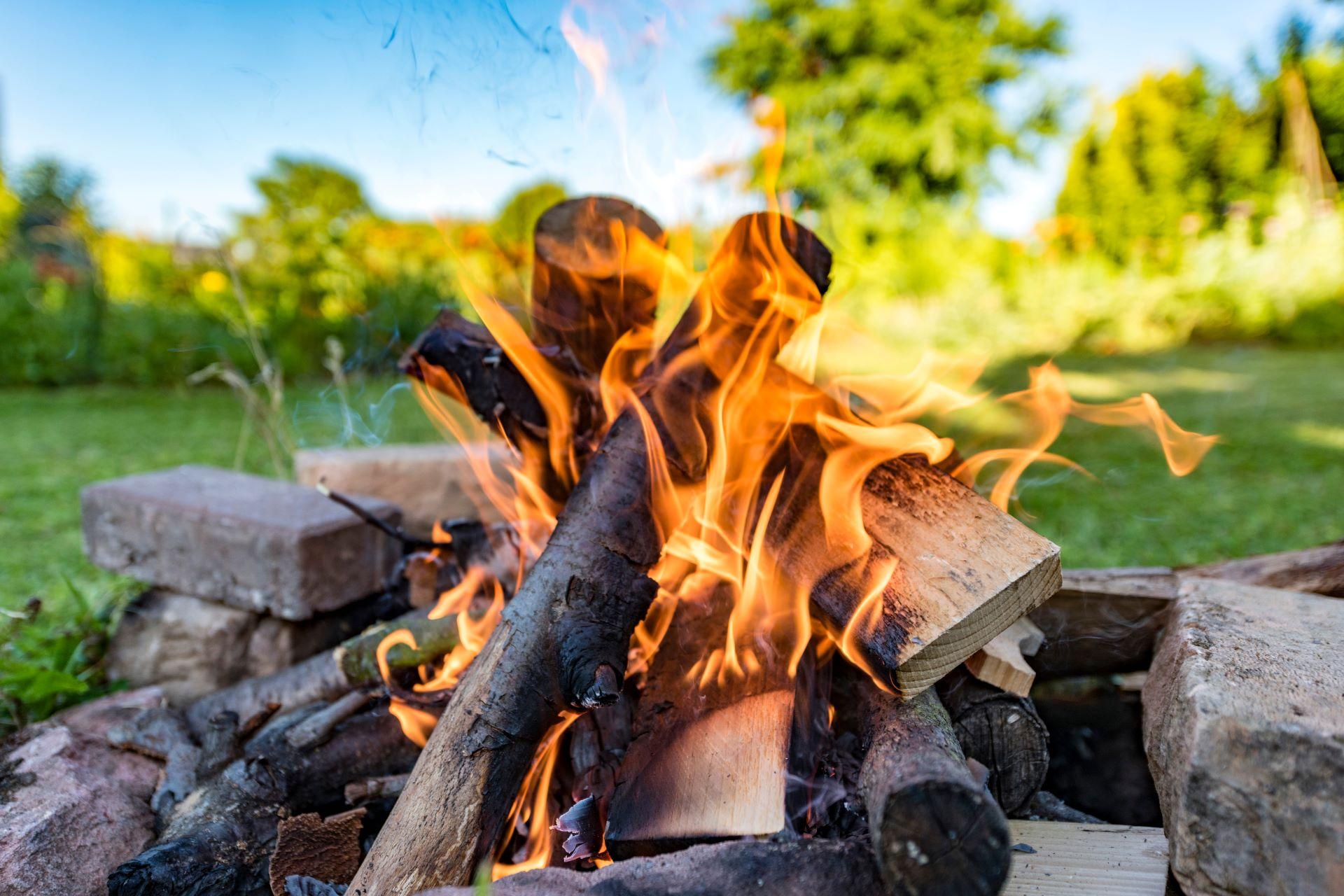 Lagerfeuer mit brennendem Brennholz im Garten