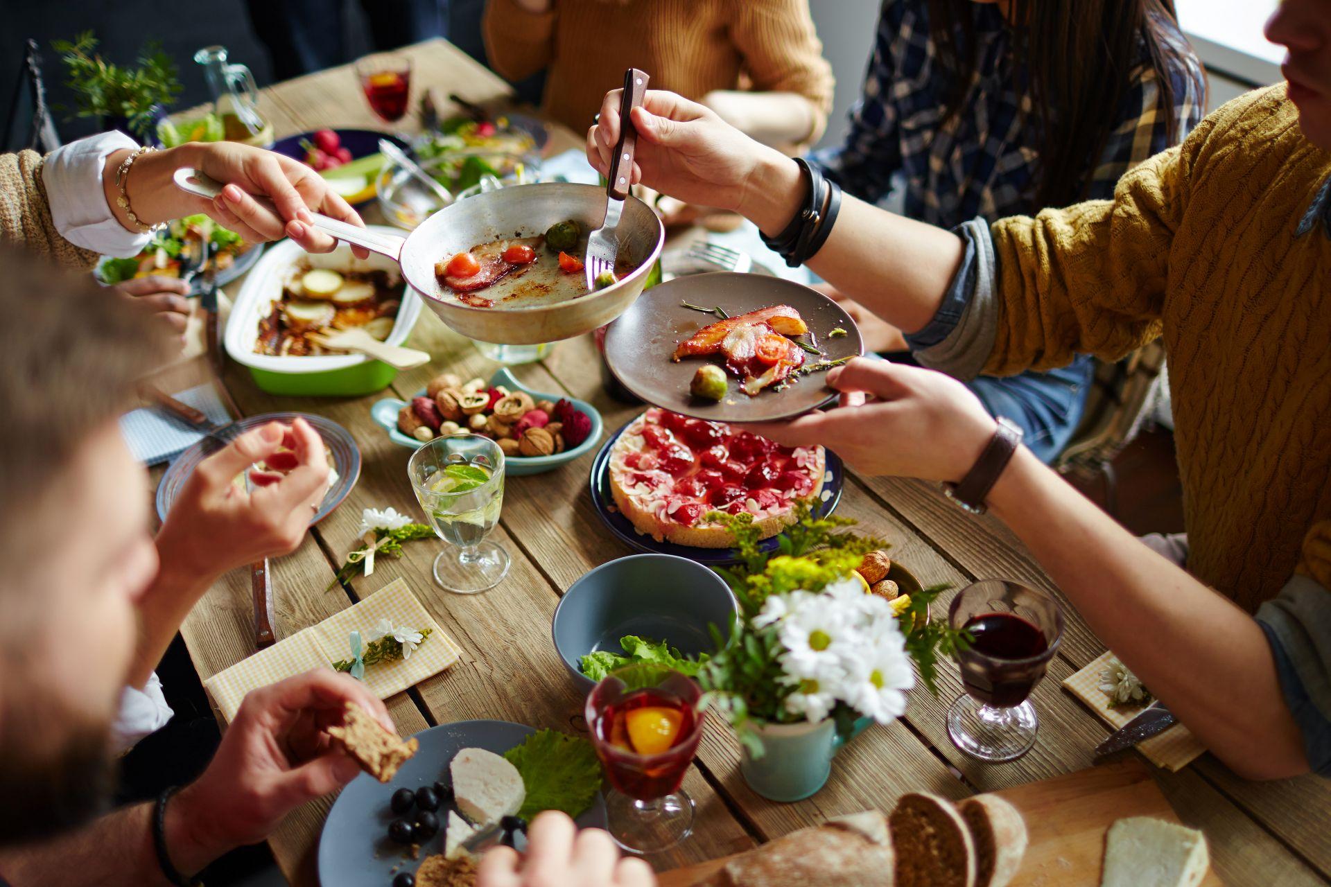 Freunde essen gemeinsam frisch zubereitete Speisen, Gemüseschneider elektrisch