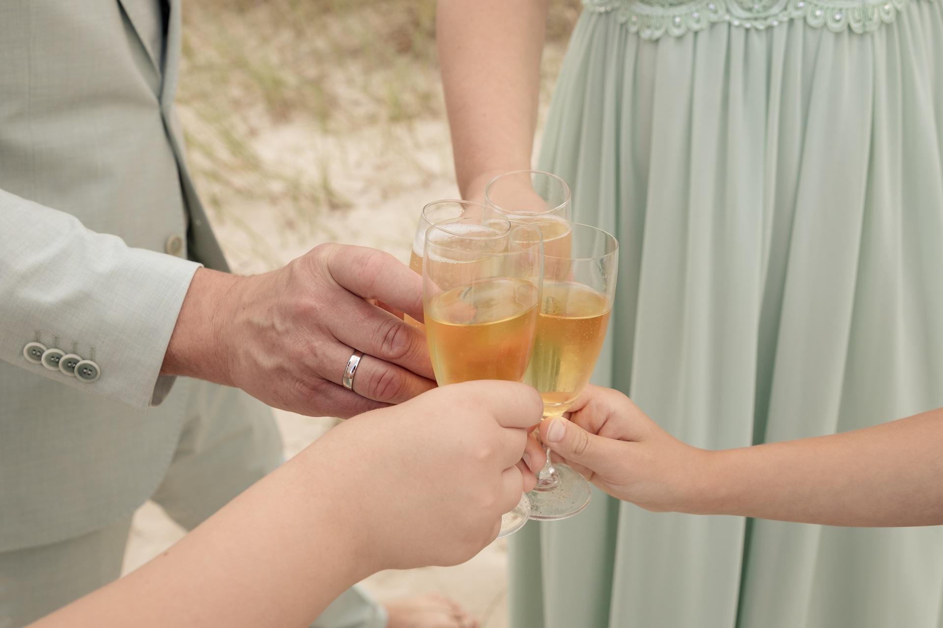 Gäste stoßen mit Sektgläsern bei festlichem Empfang an | Stehtischhussen